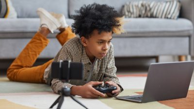 African Boy playing on alienware gaming laptop