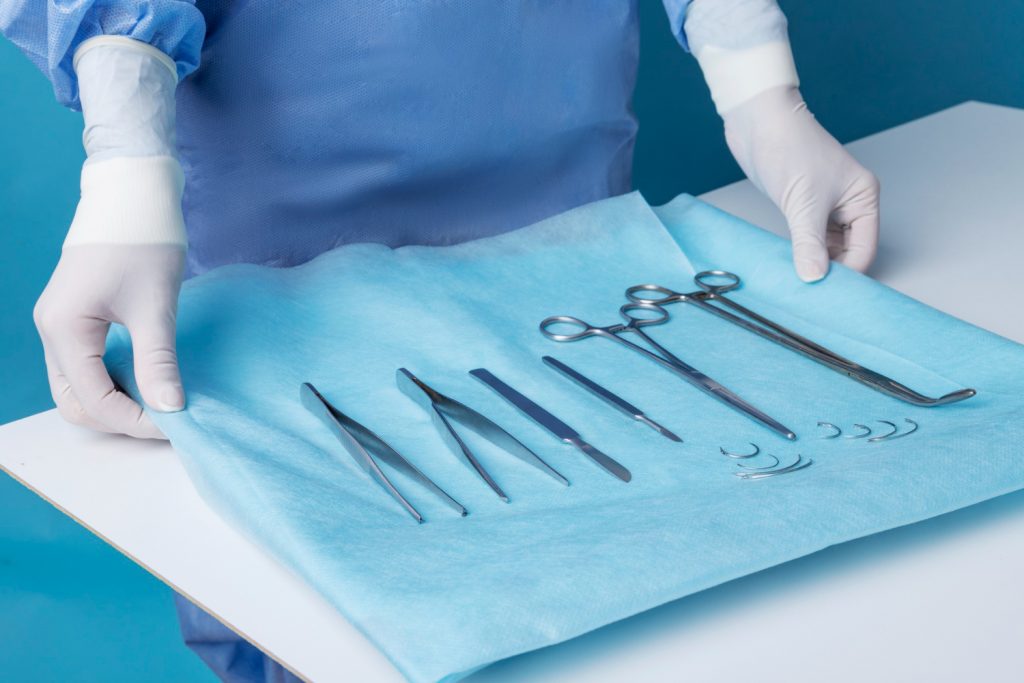 surgeon holding a tray of medic tools