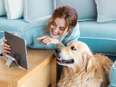 smiley woman with dog looking at online vet supply store