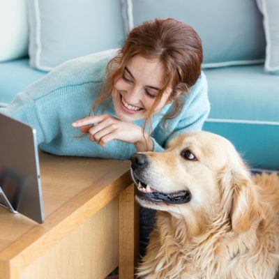 smiley woman with dog looking at online vet supply store