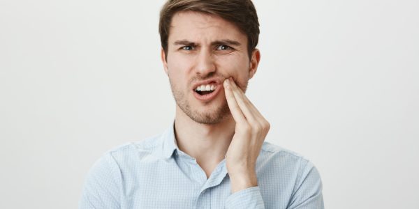 a man feeling pain after teeth extraction